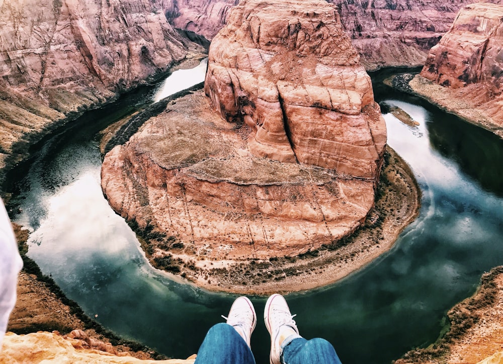 brown rock formation in front of body of water