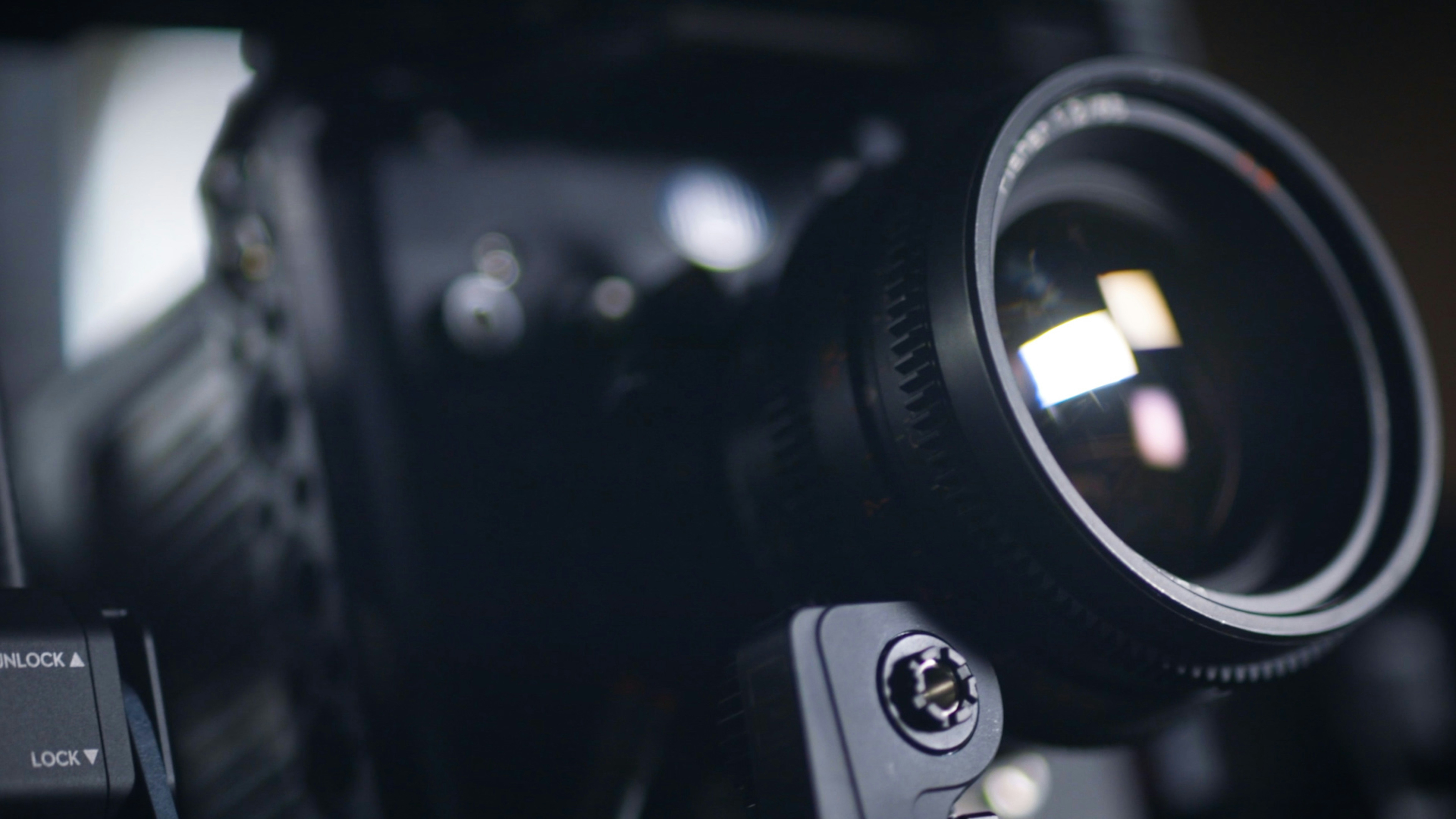 Camera lens close-up in dark workshop, metallic reflections, professional photography equipment