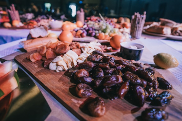 closeup photo of dates and breads on brown wooden tray