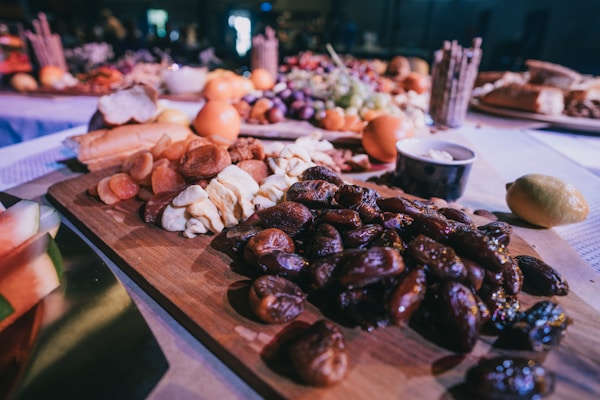 Closeup photo of dates and breads on brown wooden tray