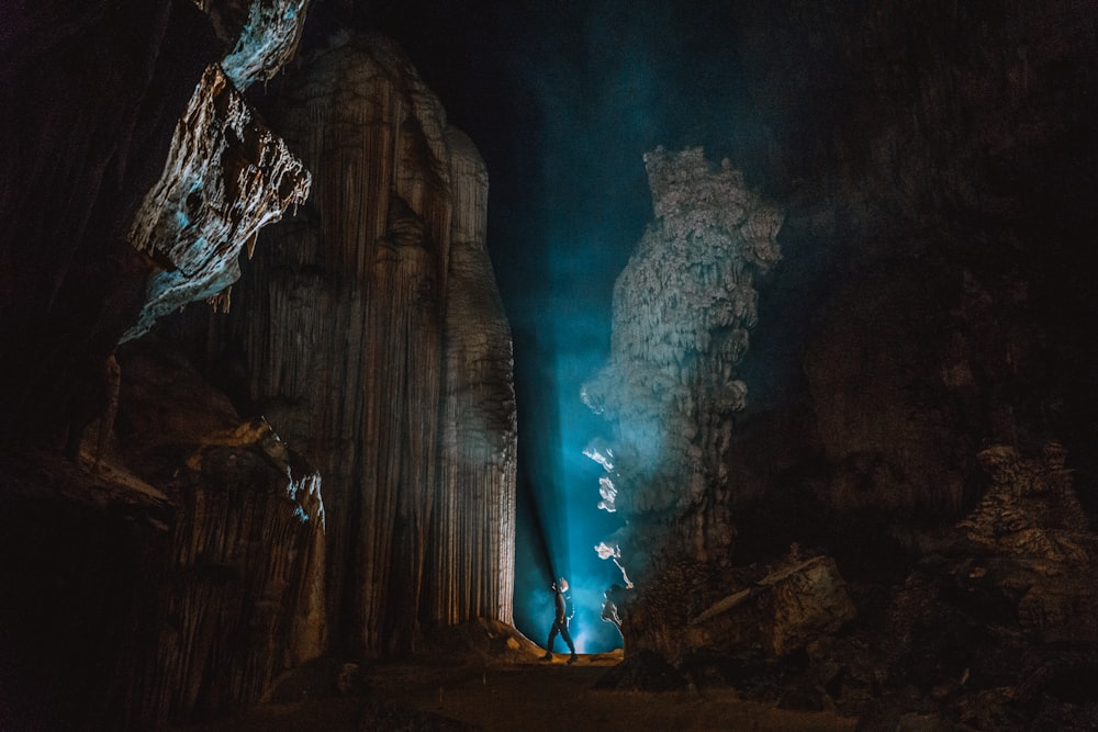 man standing near rock formation at night