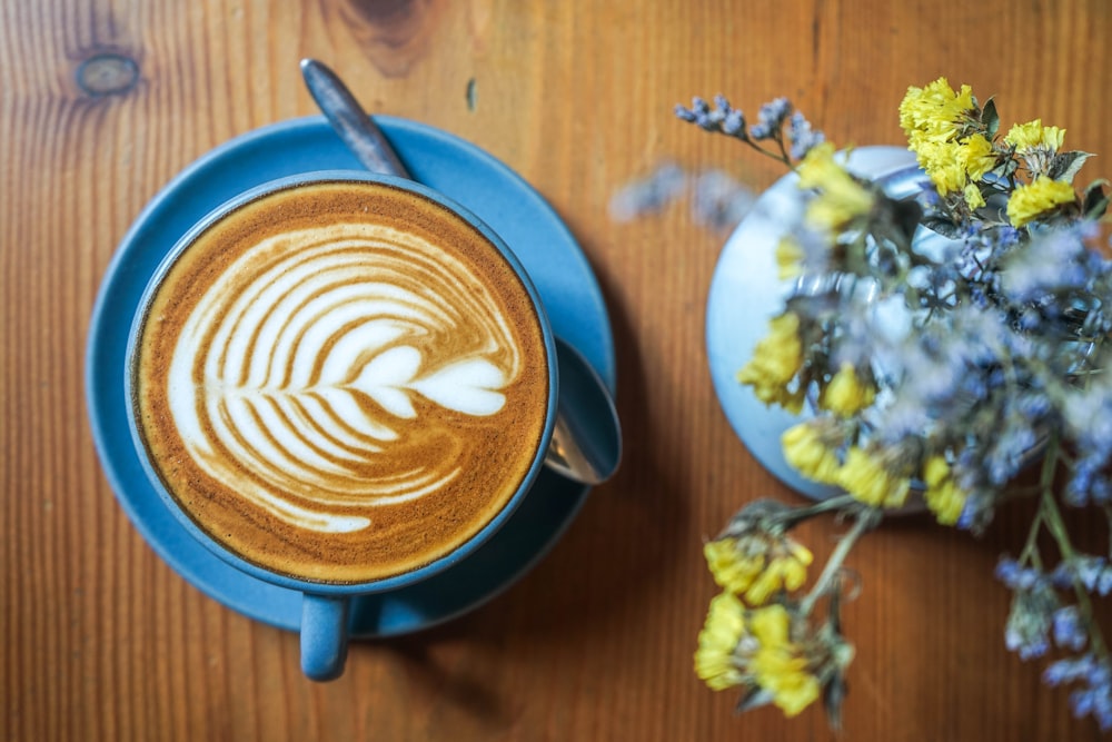 花の近くのコーヒーのフラットレイ写真