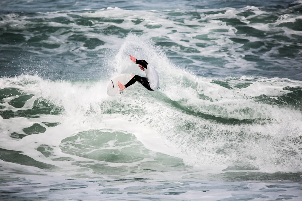 persona che fa surf sulla spiaggia durante il giorno foto
