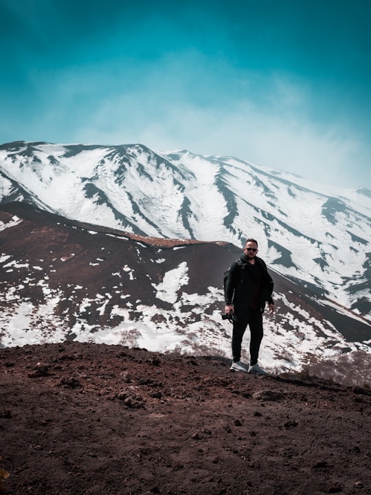 man standing near mountain during daytime in Mount Etna Italy