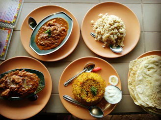 A vibrant spread of Indian dishes including chicken curry, prawn curry, and biriyani served in traditional bowls.