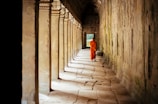 selective focus photography of monk at corridor