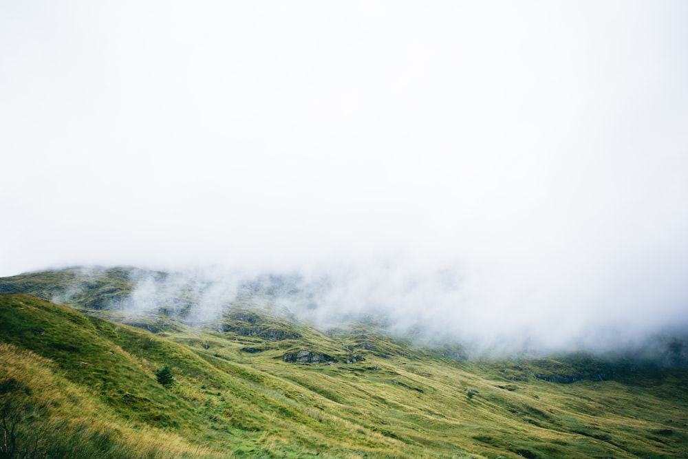 time lapse photography of hill and clouds