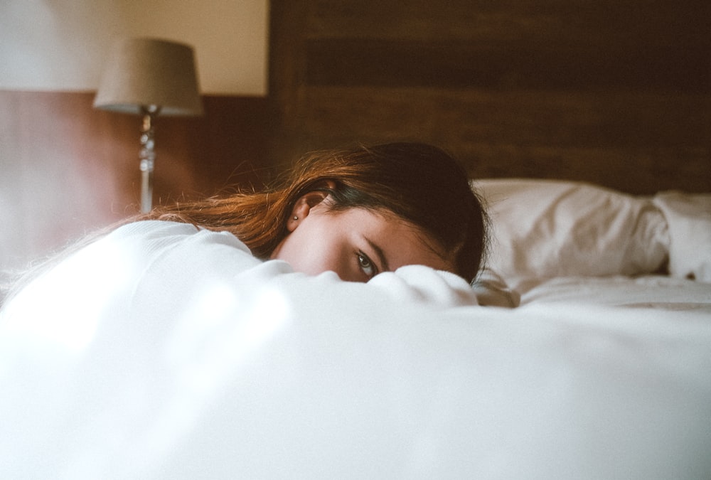 Frau legt ihren Kopf auf das Bett