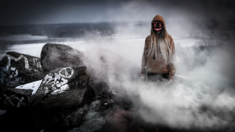 person wearing black mask and brown pullover hoodie