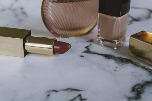 Close-up of a vibrant lipstick collection arranged artistically on a marble surface.