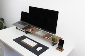 black flat screen monitor on brown and white table