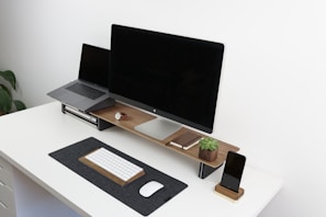 black flat screen monitor on brown and white table