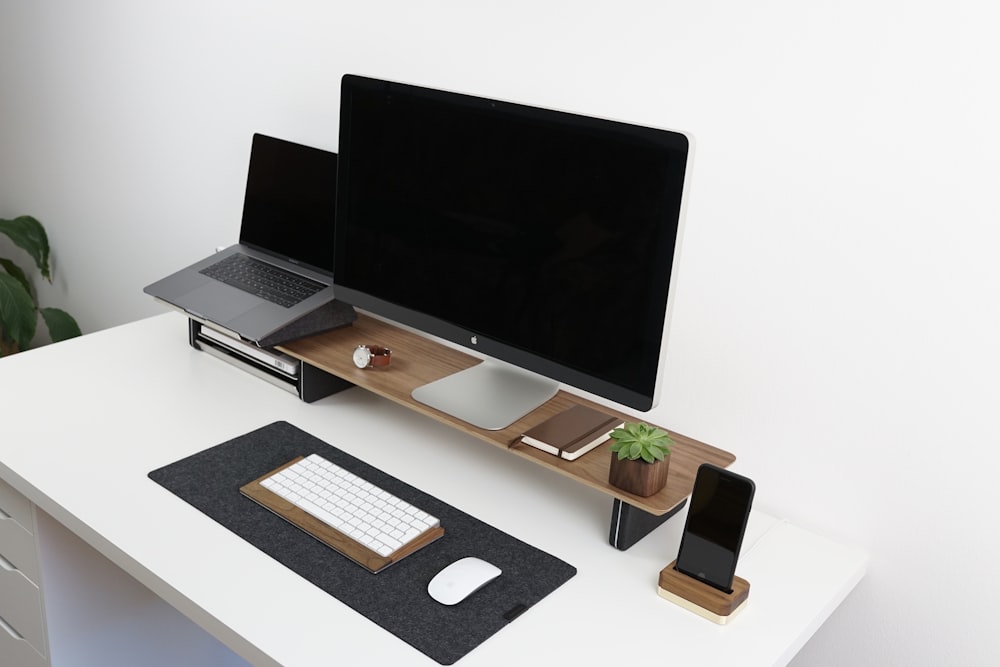 monitor a schermo piatto nero sul tavolo marrone e bianco