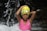 Smiling young girl in a swimming cap and goggles, standing poolside at Aquafit Academy.