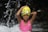 Smiling young girl in a swimming cap and goggles, standing poolside at Aquafit Academy.