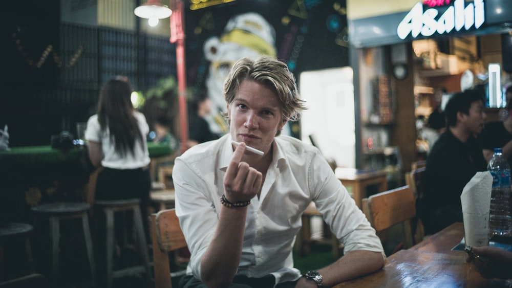 man in white dress shirt seating on chair