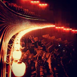 A vibrant evening gathering under warm lights inside the rustic auditorium.