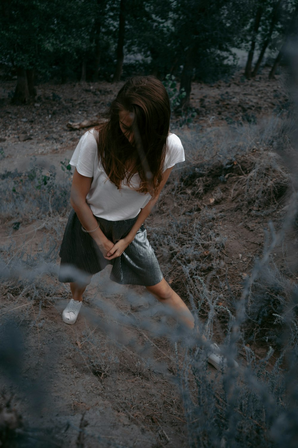 mulher em pé no chão cercada por árvores