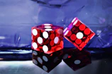 Game box art featuring fiery red and icy blue dice locked in a dramatic battle arena scene.