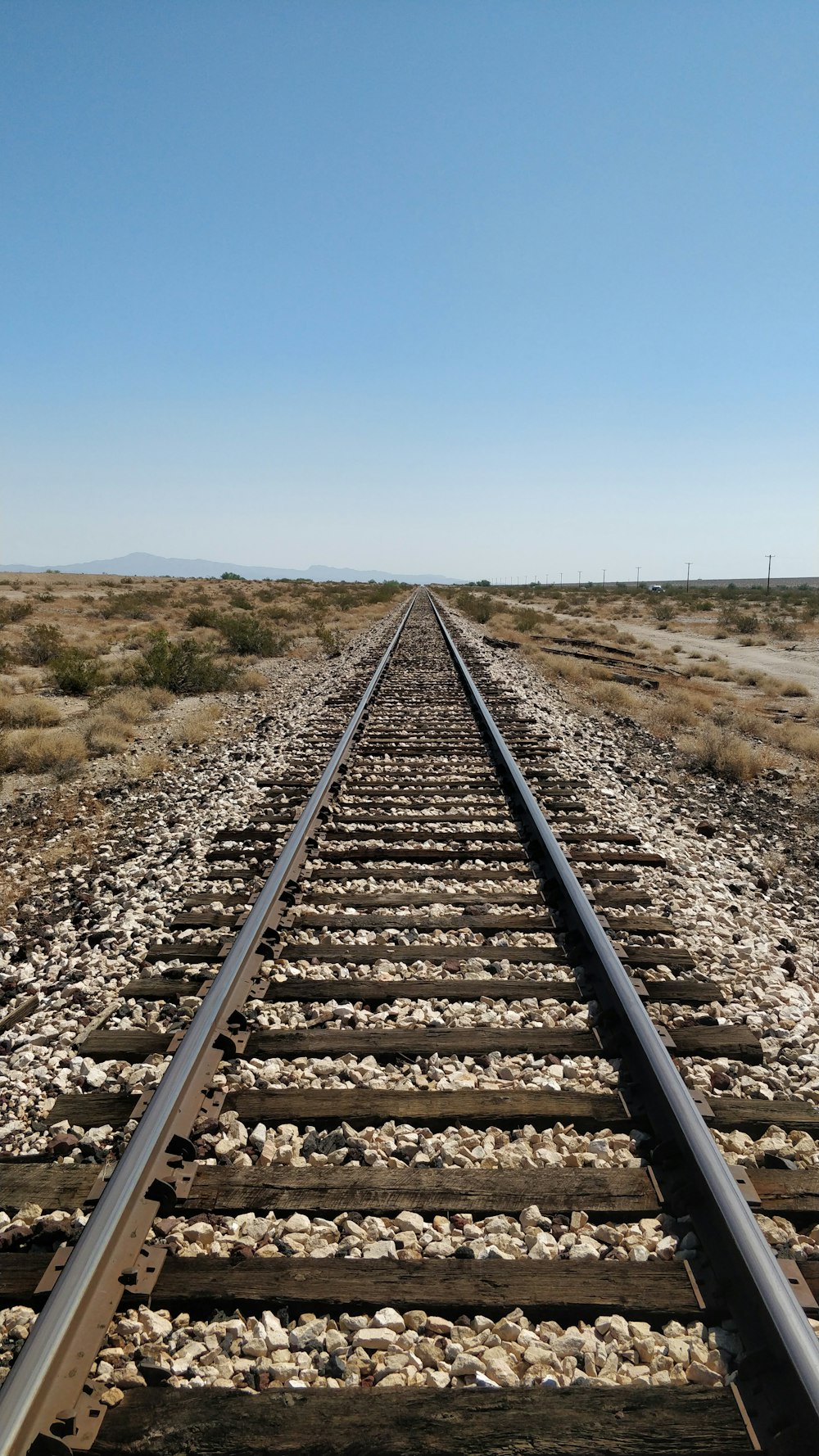 train track under blue sky