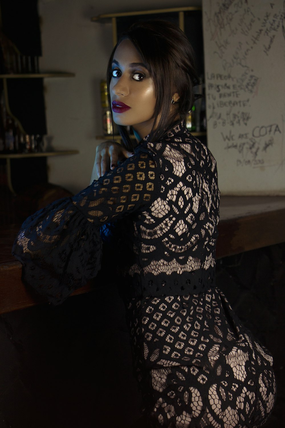 woman wearing black lace dress near bar counter