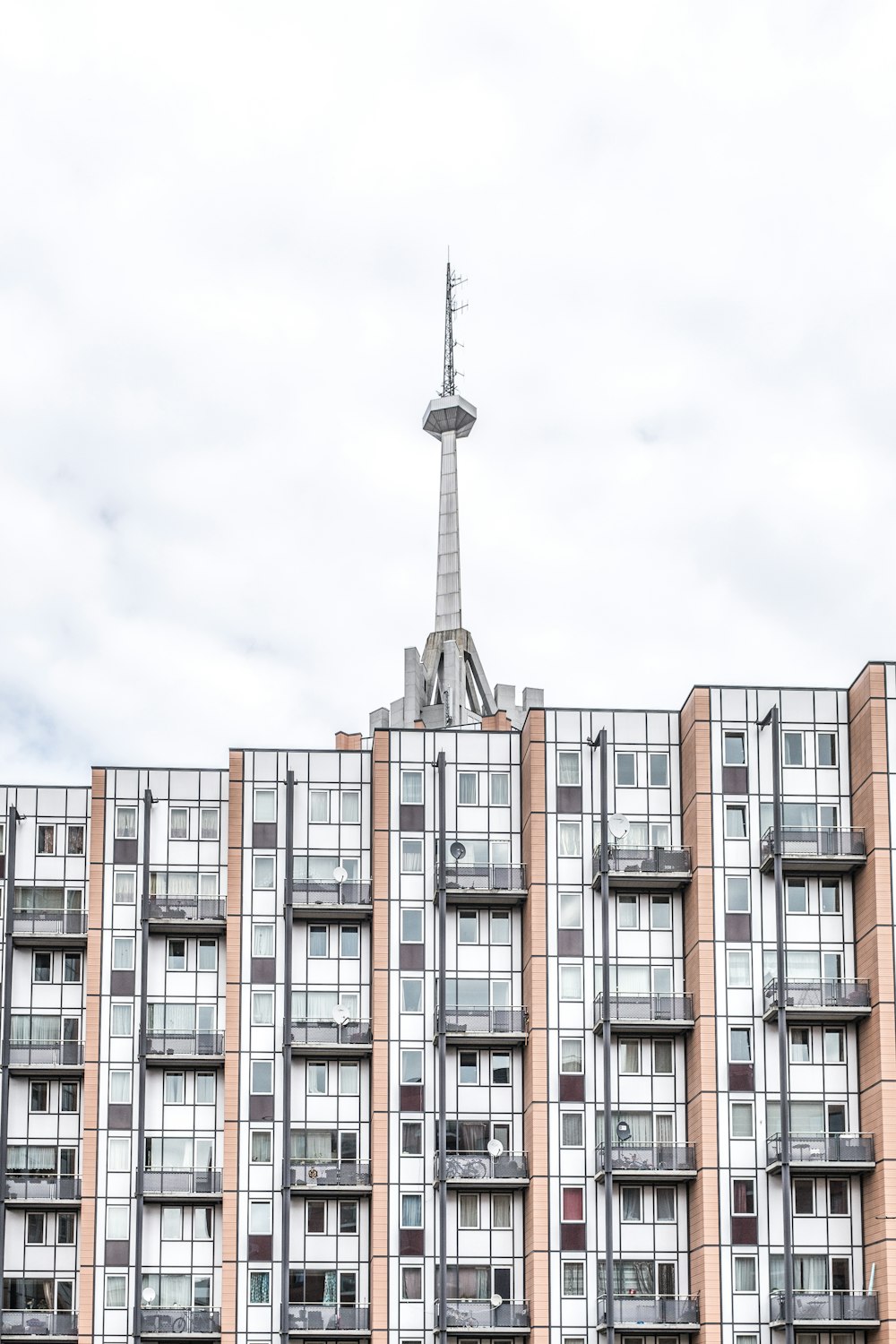 edifício pintado de marrom e branco e torre durante o dia