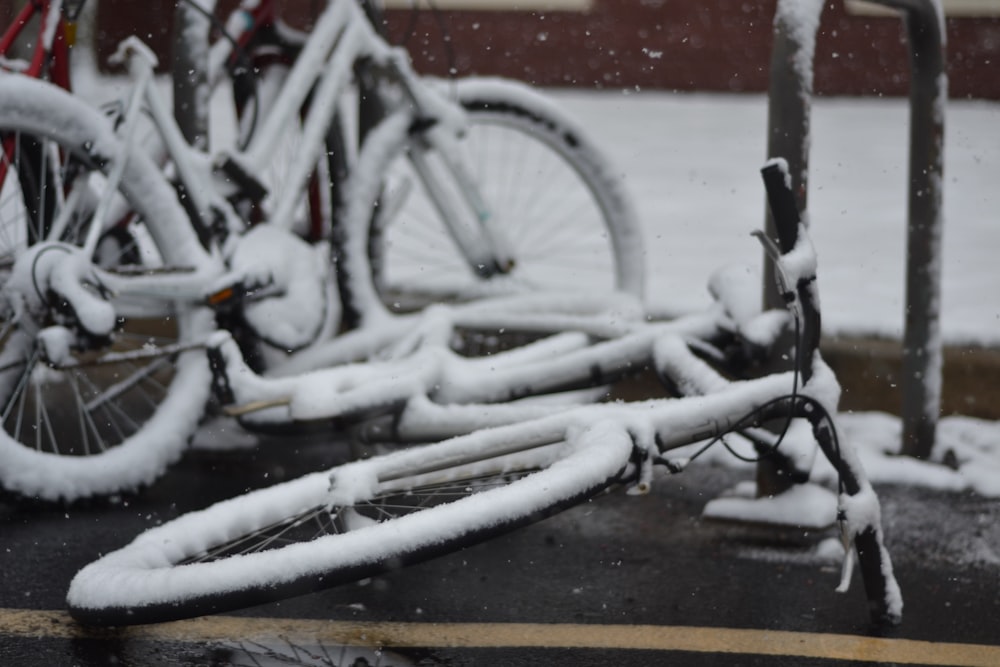 two snow covered bicycle on street