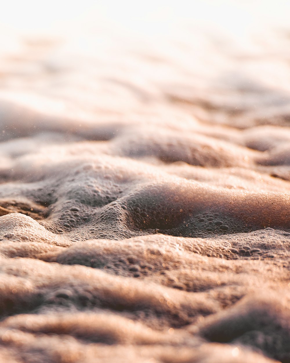 a close up of sand and water on a beach