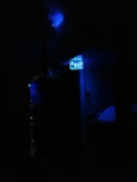 A dim environment with a focus on a digital display emitting a blue light. The surroundings are dark, making the illuminated display the primary visible element.