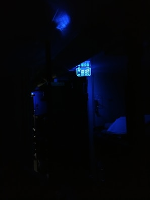 A dim environment with a focus on a digital display emitting a blue light. The surroundings are dark, making the illuminated display the primary visible element.