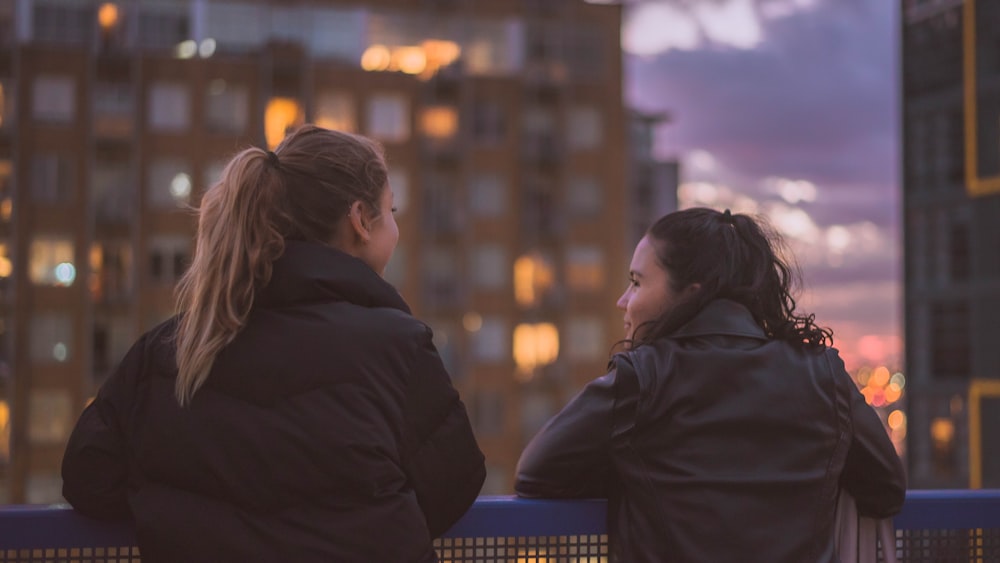 Dos mujeres de pie cerca de las barandillas