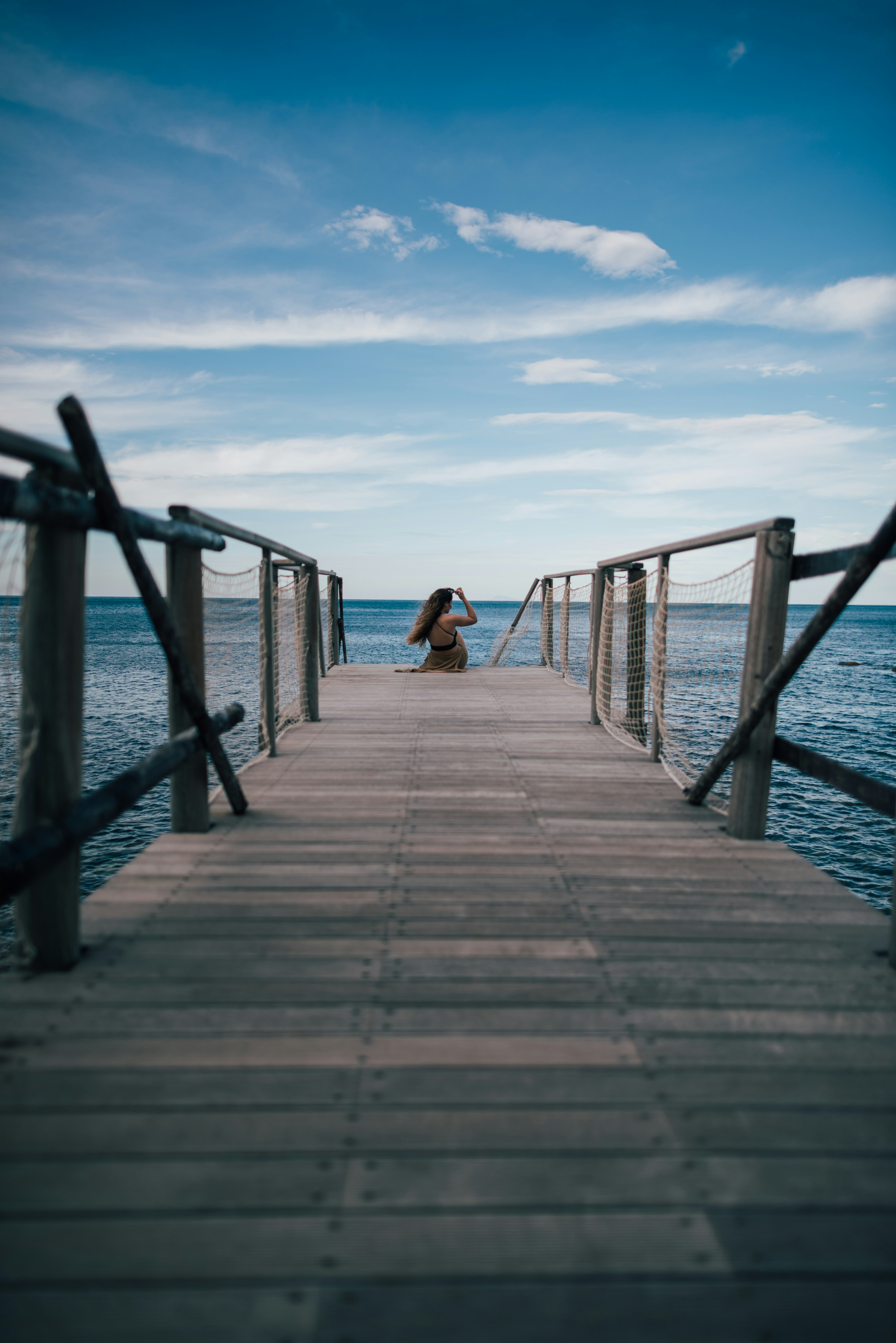 woman sitting on sea dock