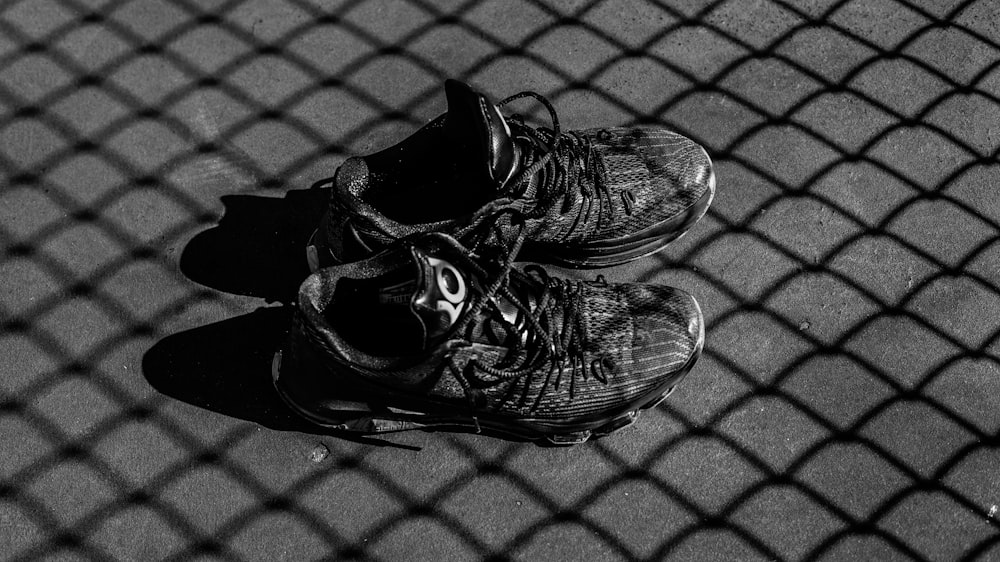 pair of black basketball shoes on gray surface