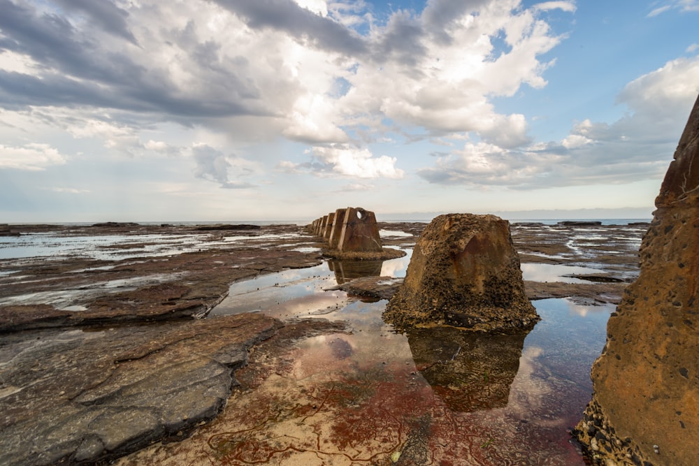 brown rock formation surrounded with water