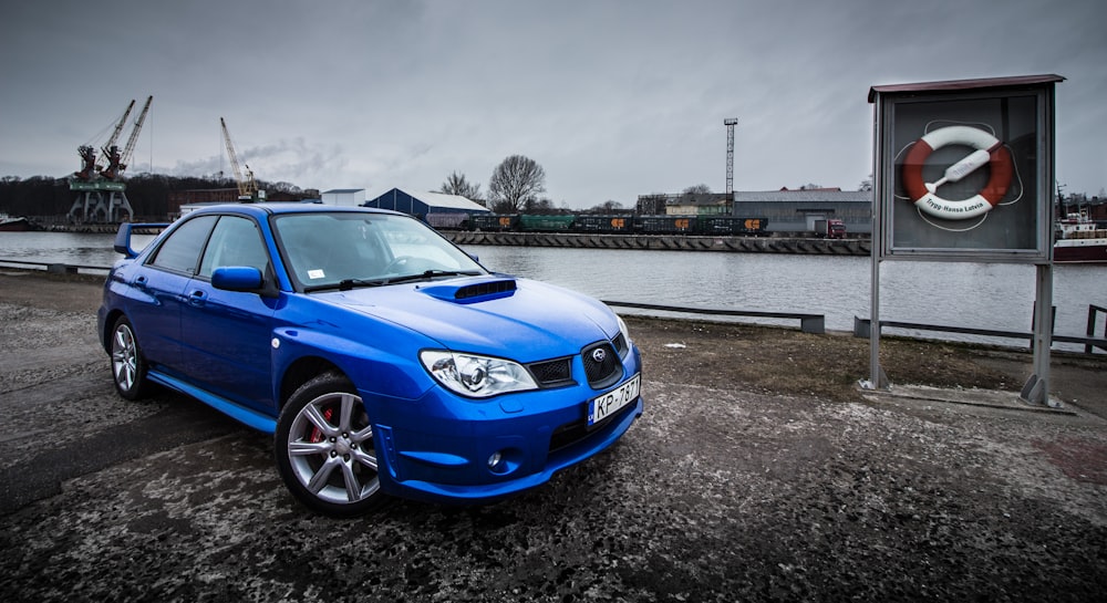 blue sedan near sea port