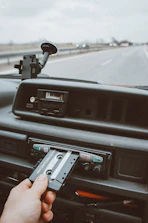 A technician installing car accessories like a stereo system in a vehicle.