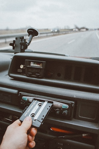 person inserting cassette tape on cassette player