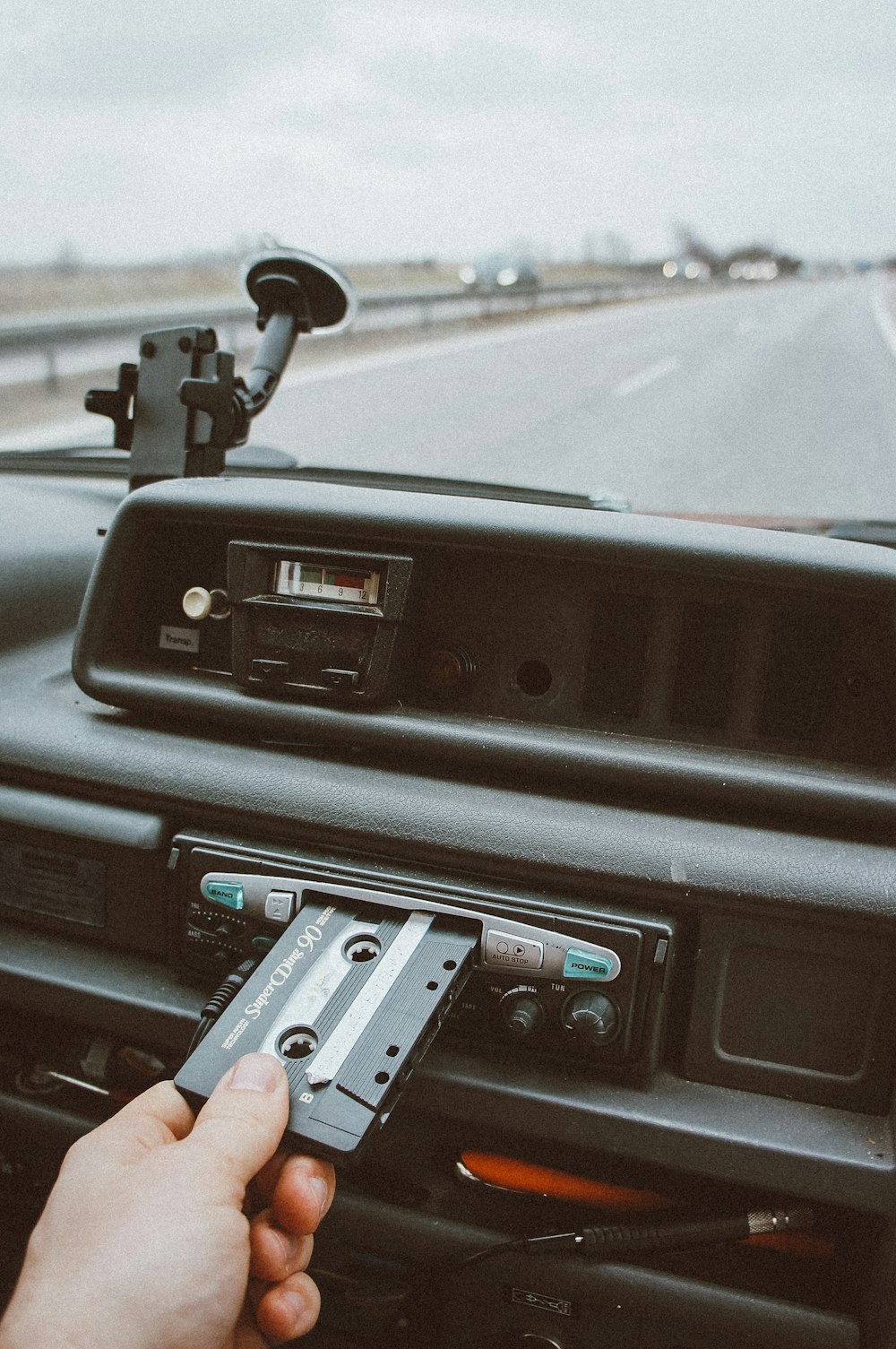 person inserting cassette tape on cassette player