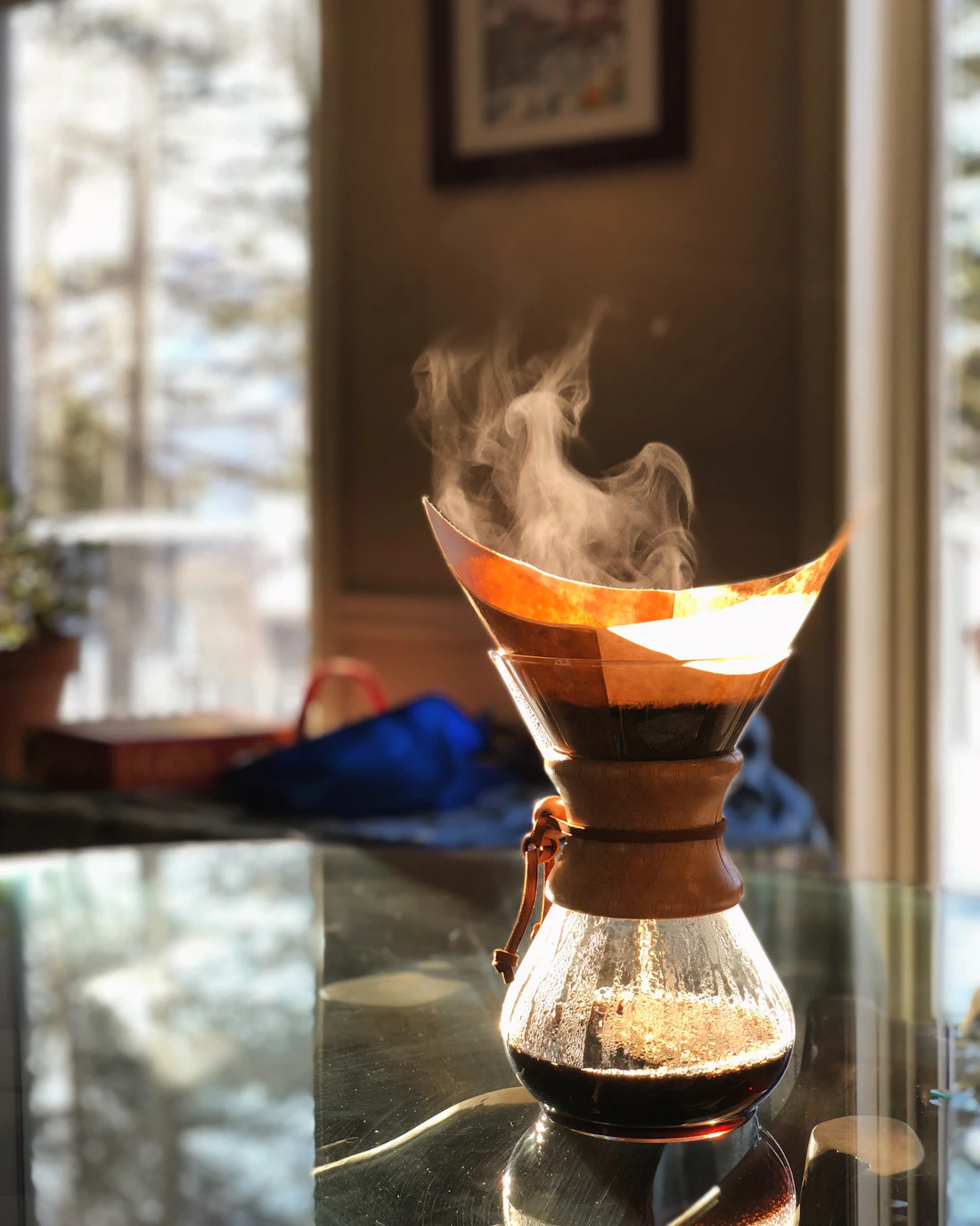 A pour-over coffee maker dripping into a glass carafe