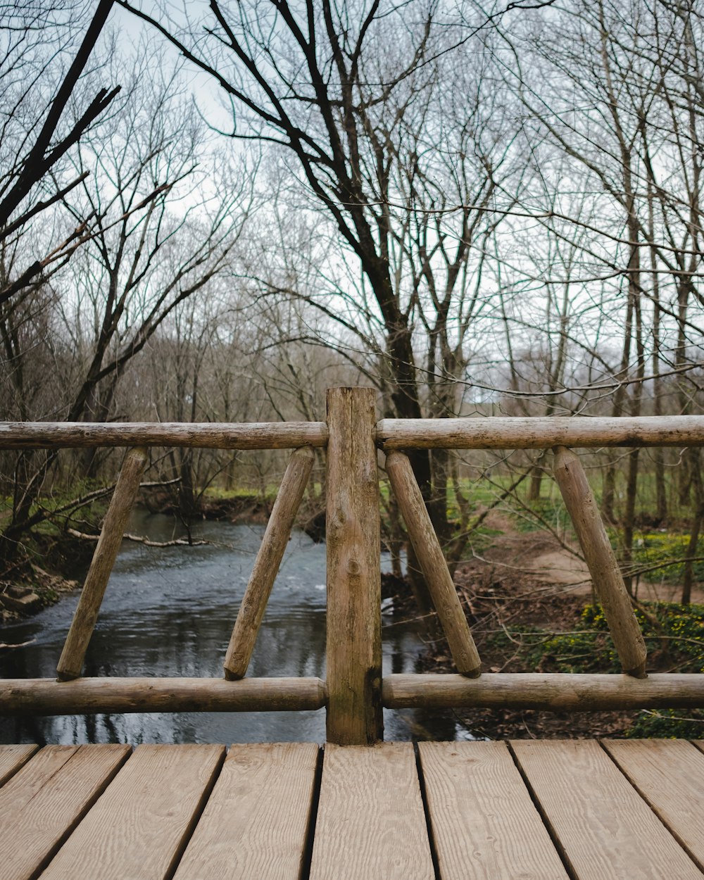 a wooden bridge over a small river in the woods