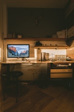 black flat screen computer monitor on desk inside dim-lit room