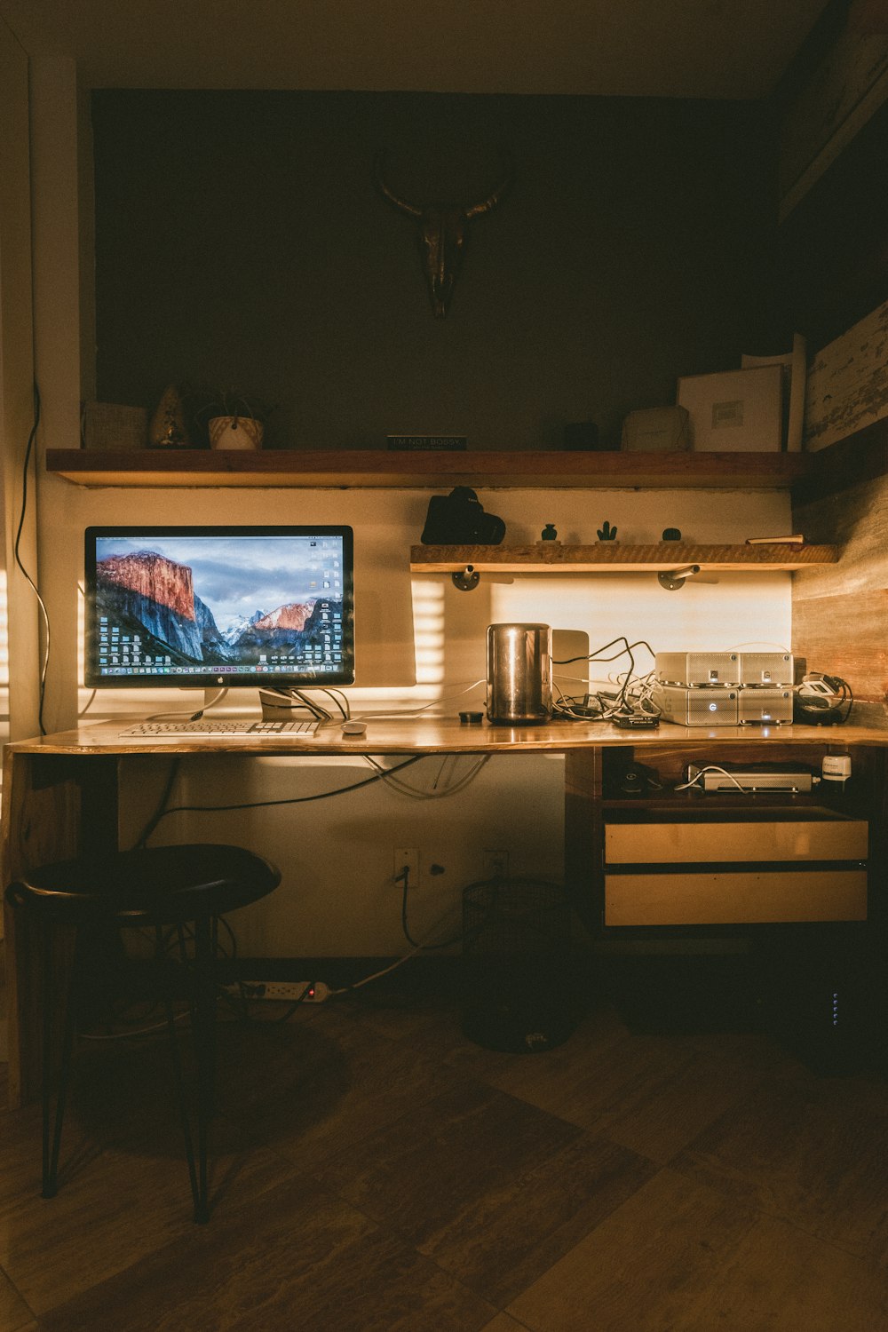 black flat screen computer monitor on desk inside dim-lit room