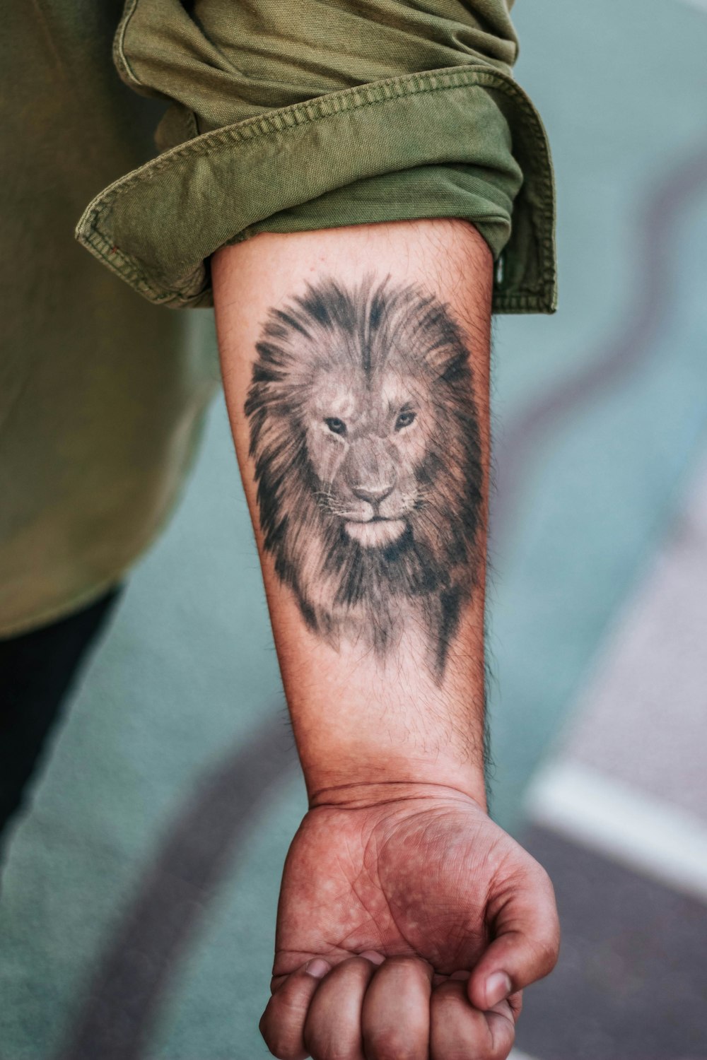 Fotografia de foco raso da tatuagem do antebraço do leão