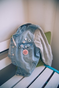 A stylish arrangement of Disney pins displayed on a denim jacket in a bustling city setting.
