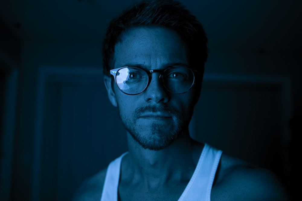 person wearing white top and black framed Wayfarer-style eyeglasses