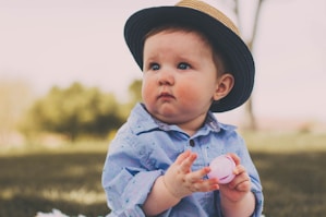 toddler holding ball while sitting