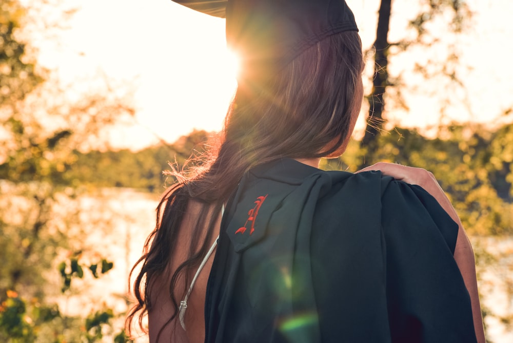 Mujer con sombrero de mortero que lleva su vestido académico al hombro