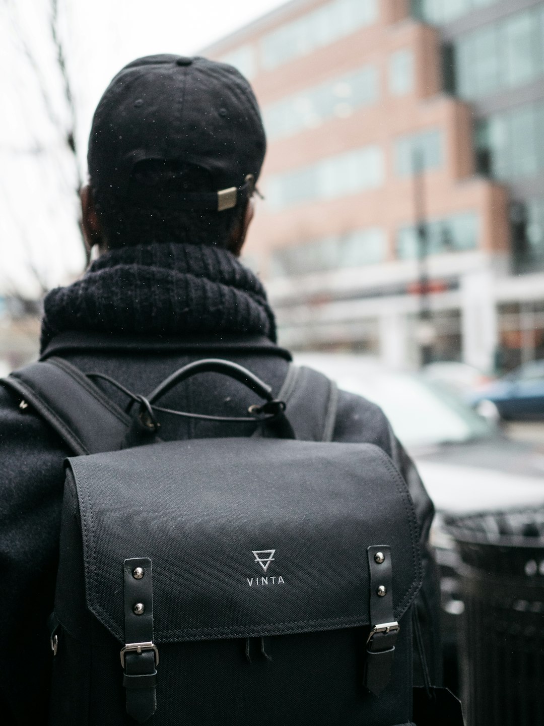 man wearing black top. hat, and Vinta backpack selective focus photography