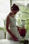 women's white sleeveless dress using smartphone on table