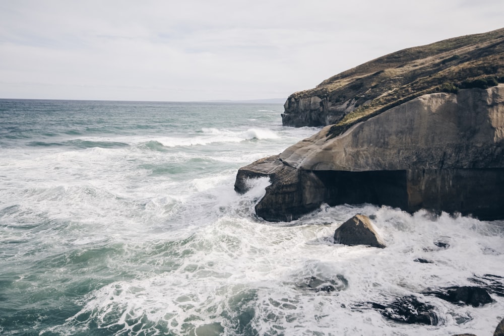 rock cliff beside body of watwer